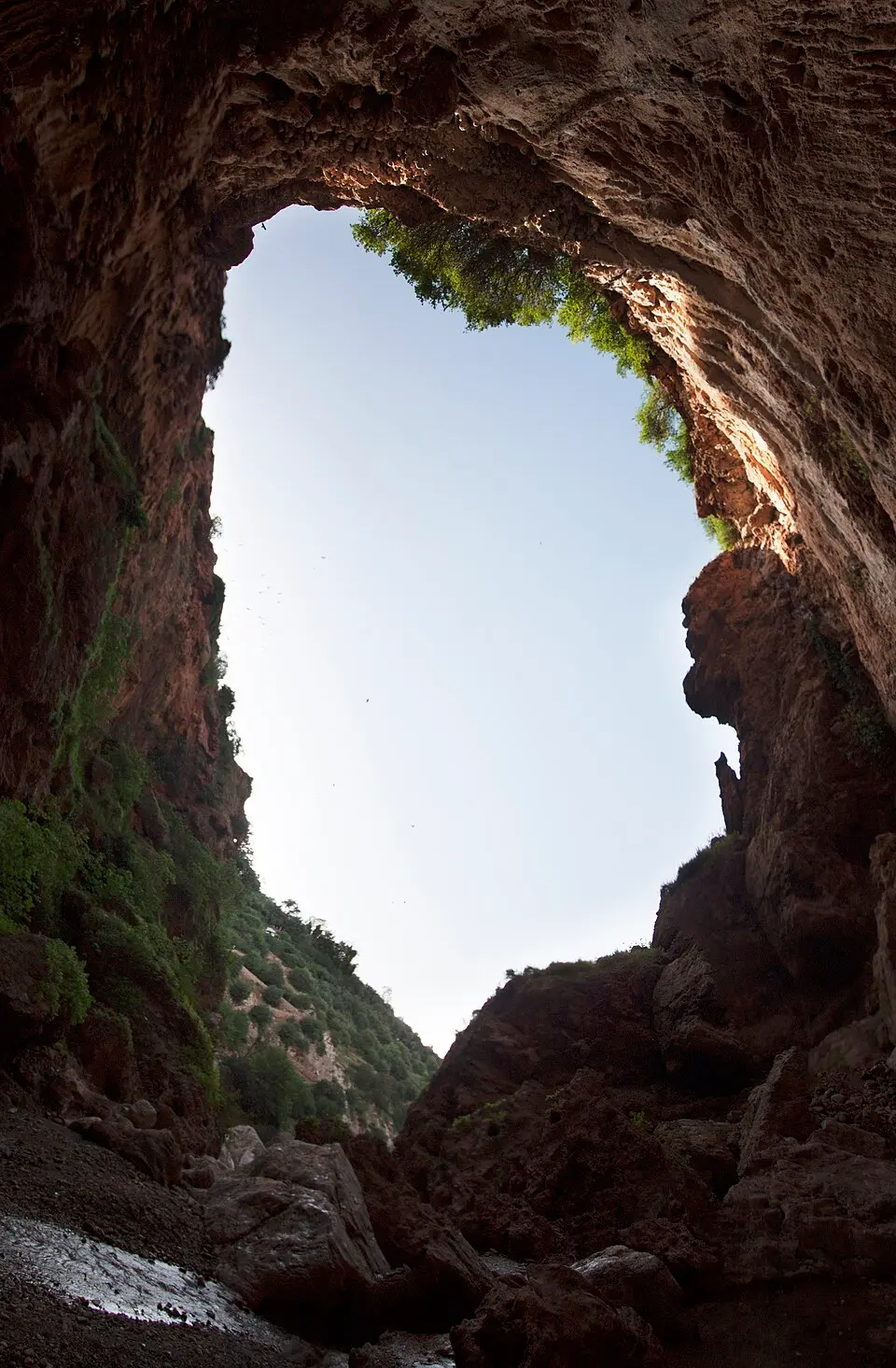 Raid mtb high atlas passing under the rock arch of Imi n’Ifri